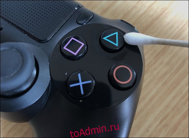 Ватная палочка, протирающая кнопку на контроллере DualShock 4. 