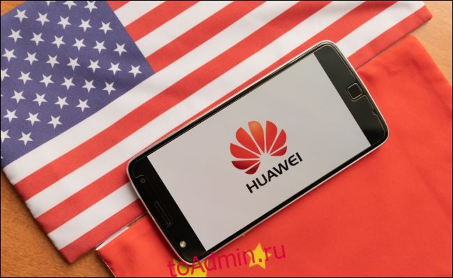 Телефон Huawei между флагом США и Китая.